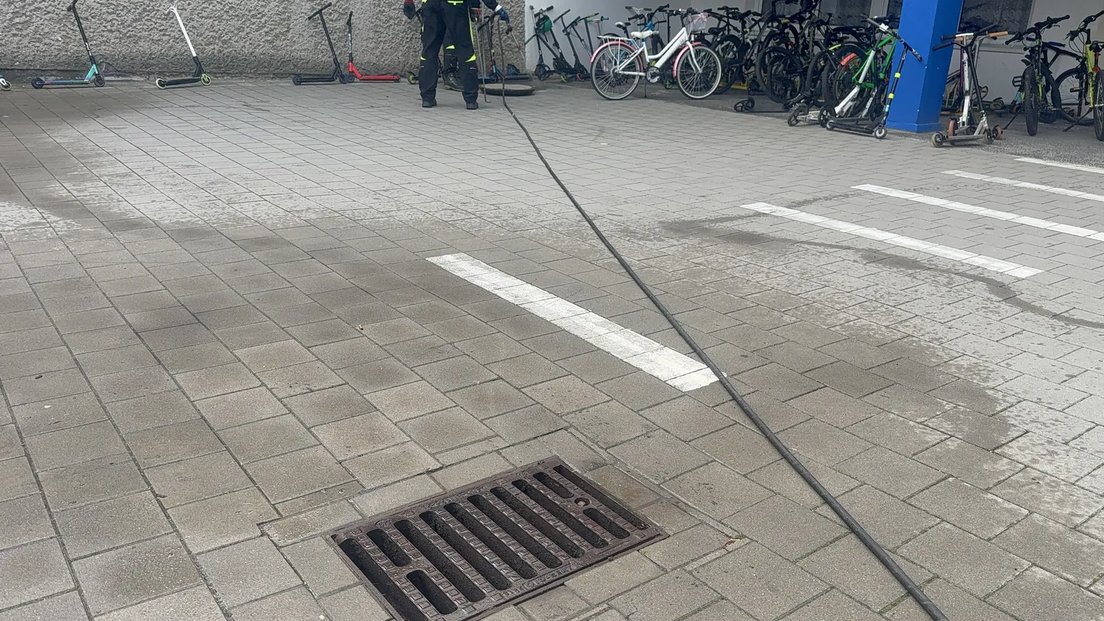 Wąż WUKO poprowadzony po placu szkolnym od wpustu drogowego do studni kanalizacyjnej