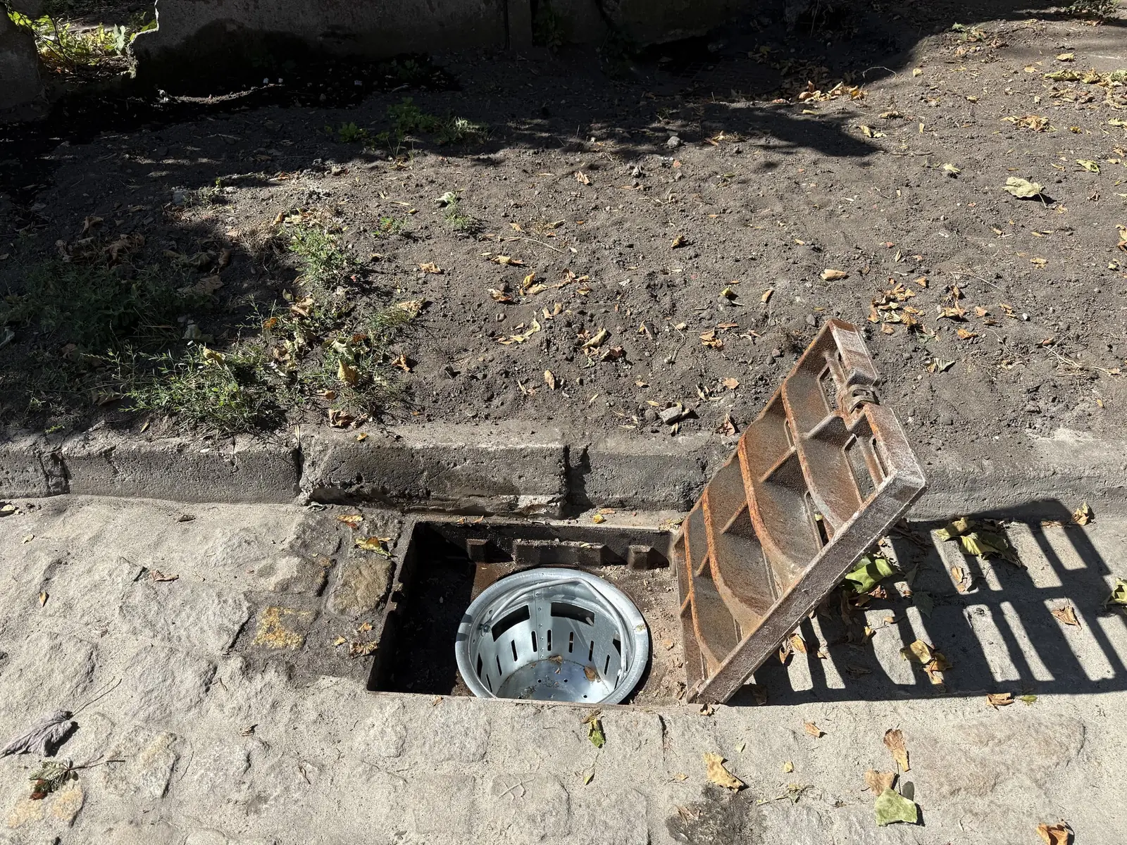 Nowy wpust deszczowy z otwartą kratą i ocynkowanym koszem na liście