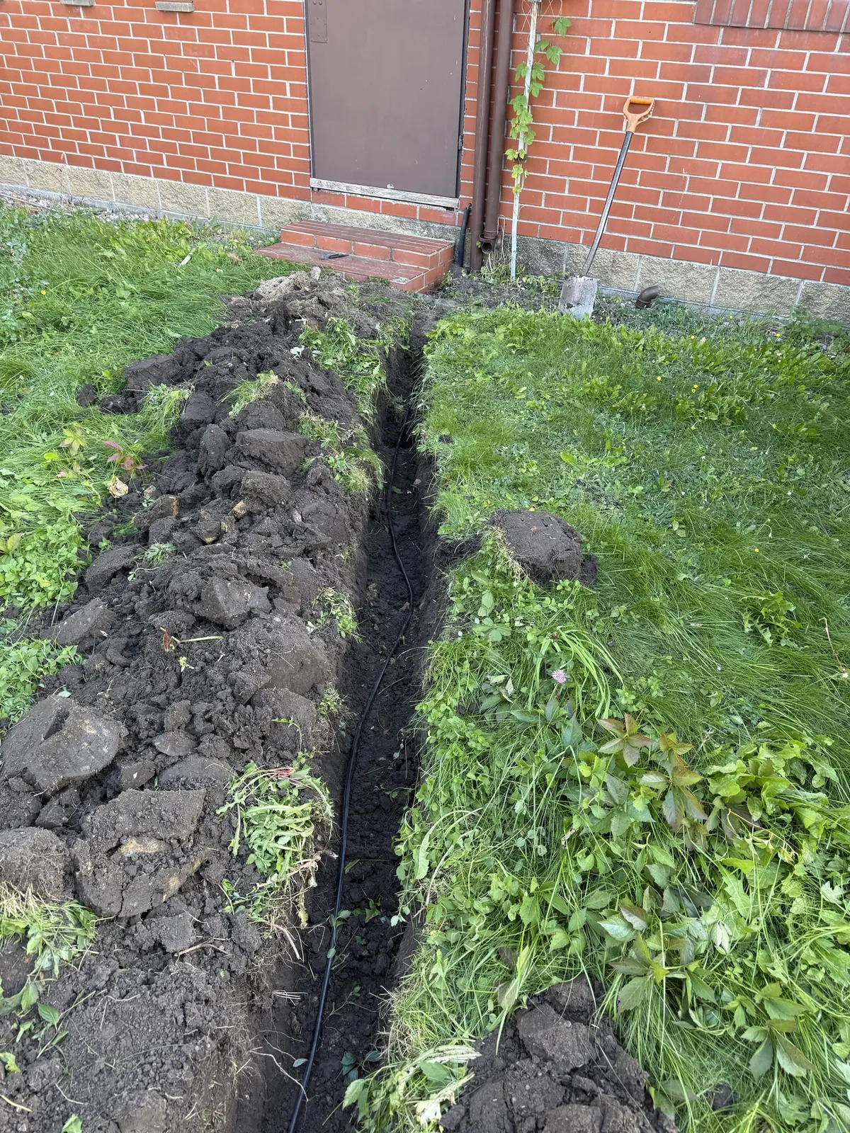 Przewód zasilający pompę ułożony w wykopie od budynku do studni przepompowni