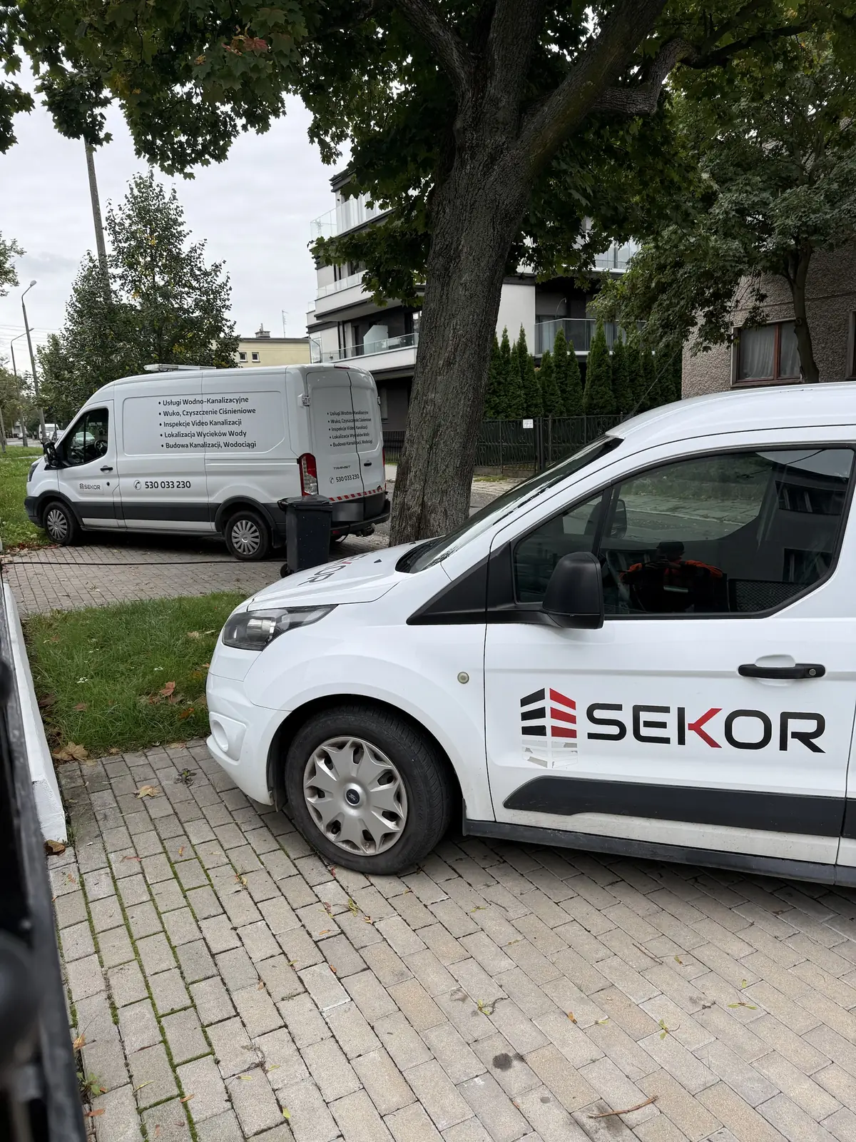 Samochody serwisowe SEKOR na osiedlu domów