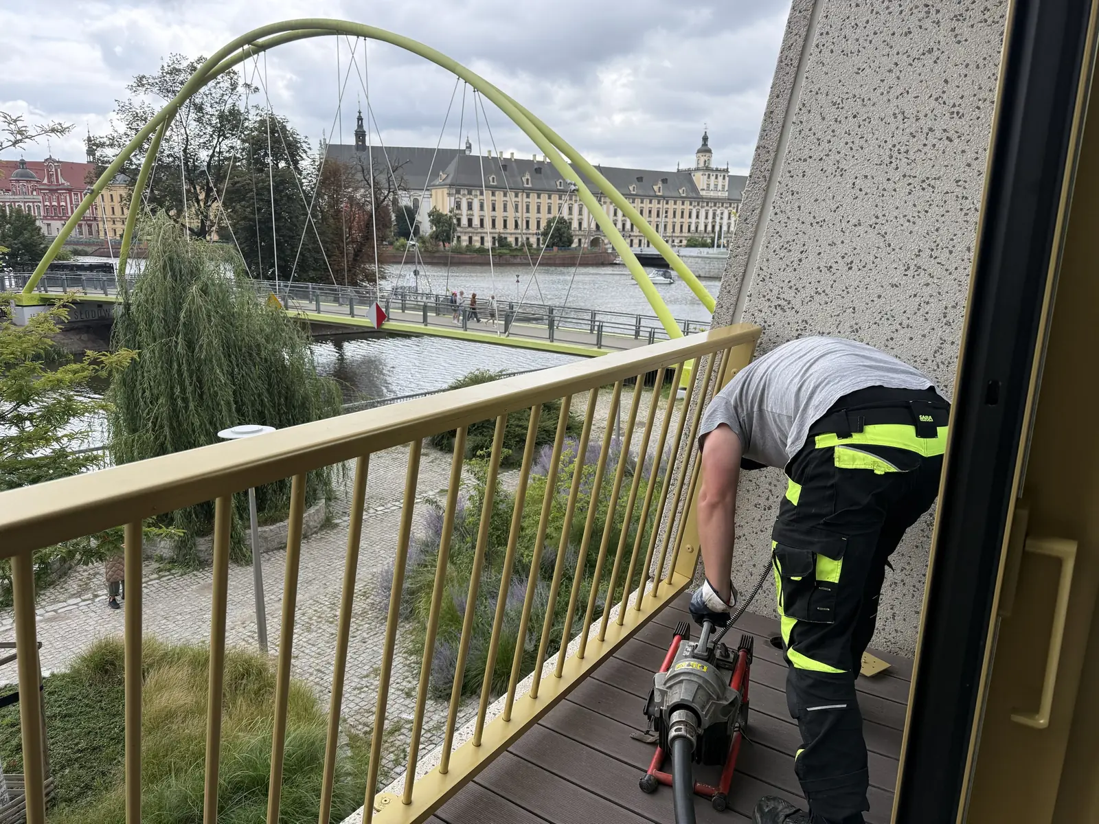 Technik SEKOR udrażnia odpływ na balkonie apartamentowca nad Odrą spiralą elektryczną