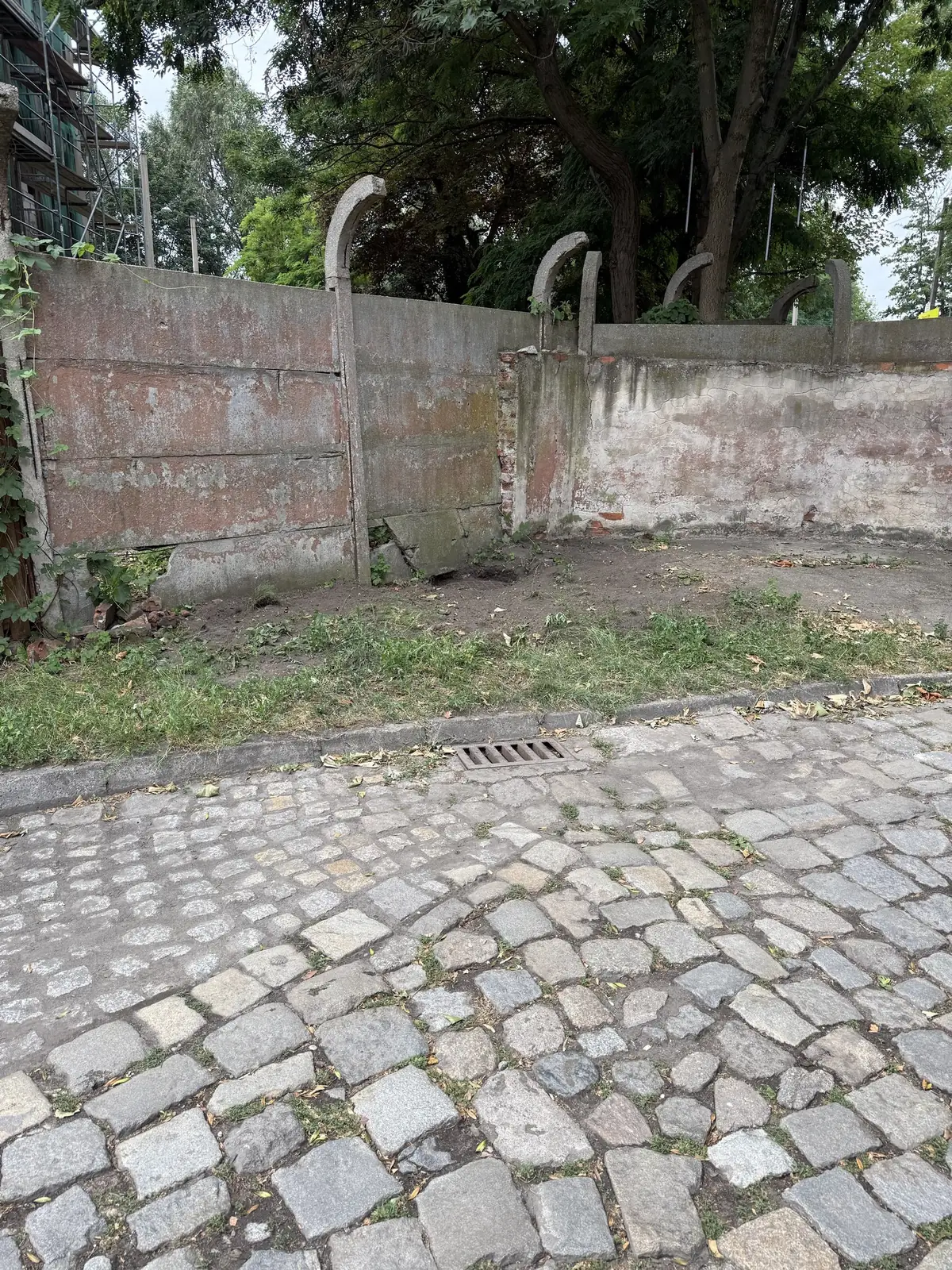 Stary wpust uliczny przy krawężniku na nawierzchni z kostki granitowej przed wymianą