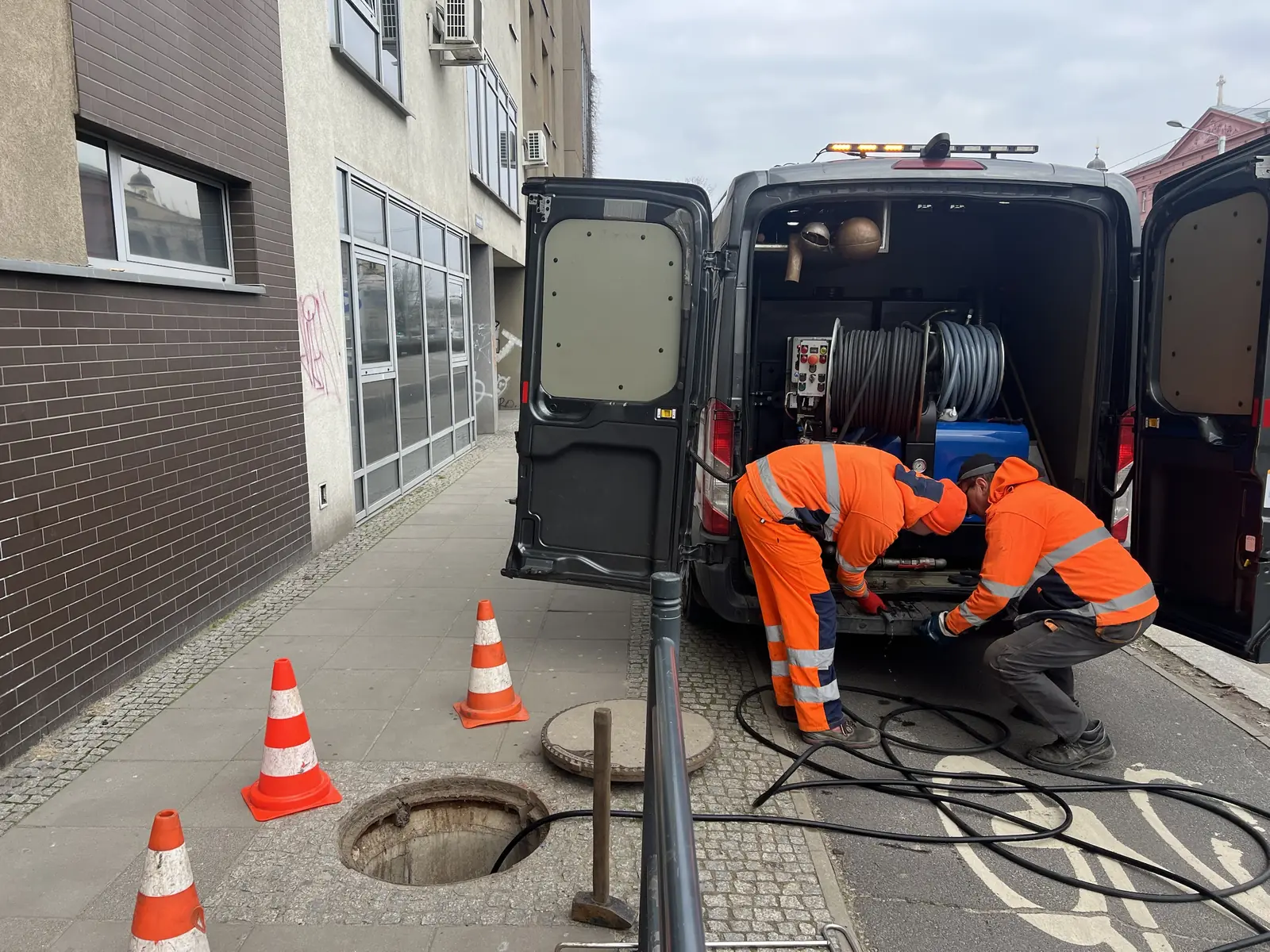Dwóch techników SEKOR w odzieży ostrzegawczej przygotowuje urządzenie WUKO przy studzience