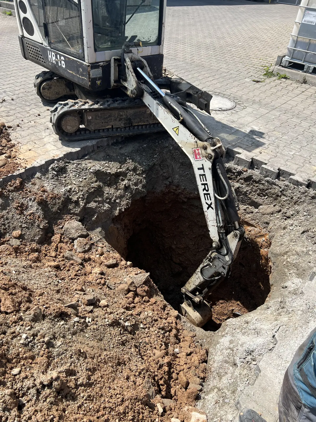 Minikoparka przy punktowym wykopie w kostce brukowej